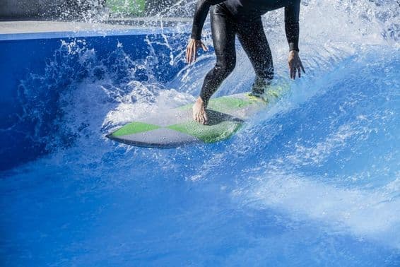 Person surft in einem Wellenbecken