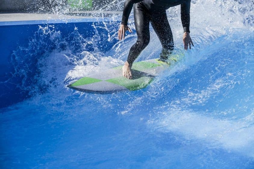 Person surft in einem Wellenbecken
