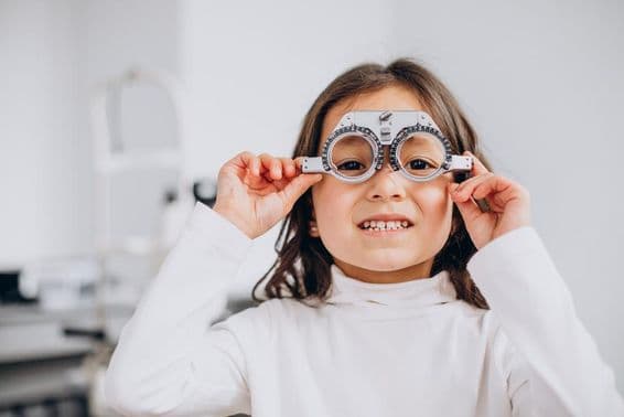 Sehbehinderte Mädchen mit Probrille beim Optiker.