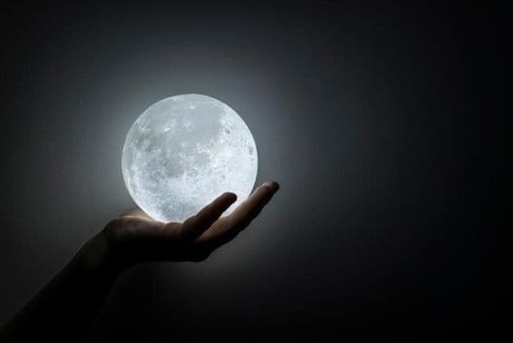 Eine Hand hält den Mond.