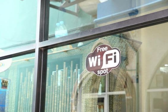 Schild in einem Café-Fenster, das kostenloses WLAN bewirbt.