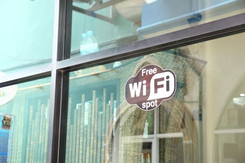 Schild in einem Café-Fenster, das kostenloses WLAN bewirbt.