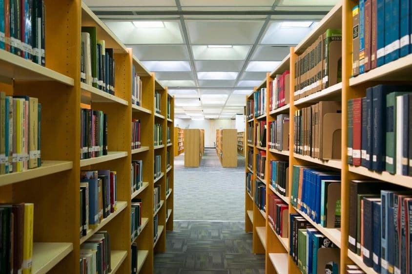 Eine Bibliothek ist sichtbar mit Regalen, die Bücher enthalten.