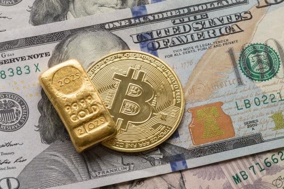 Eine Investitionsgoldbarren und eine Bitcoin-Münze über einem 100-Dollar-Schein.