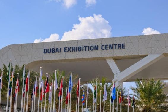 Dubai Exhibition Centre mit Flaggen im Vordergrund.