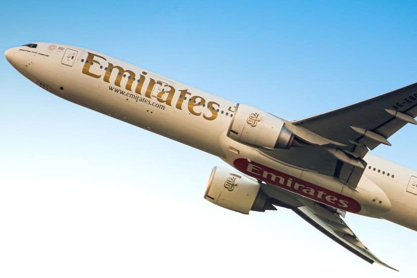 Emirates-Flugzeug am Himmel von unten sichtbar.