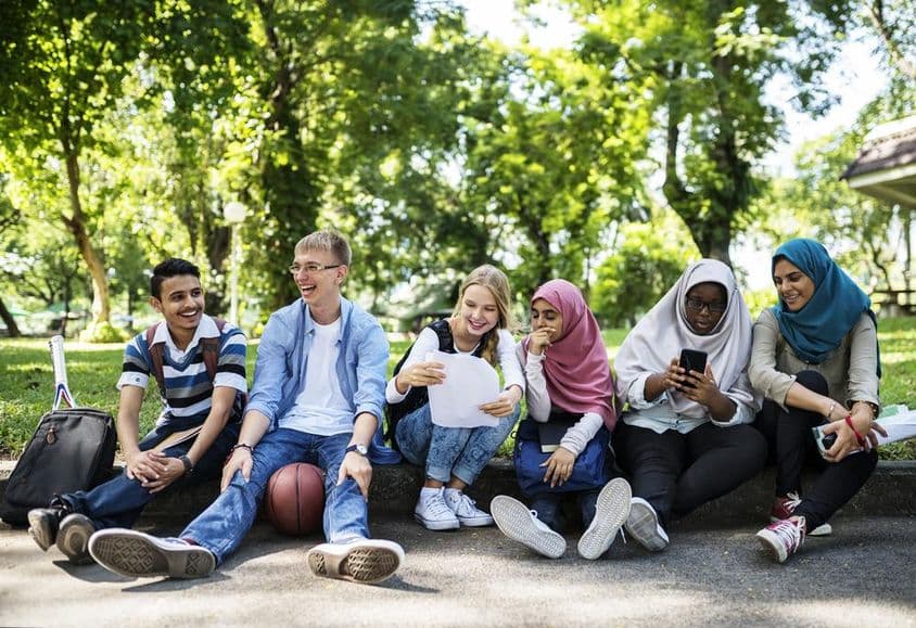 Dubai-Studenten sitzen am Straßenrand.