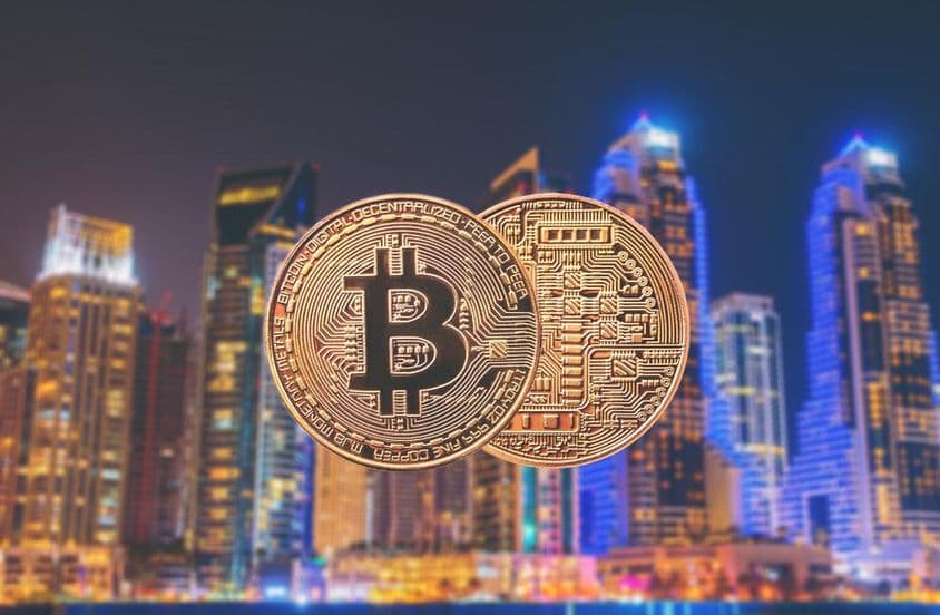 Bitcoins im Vordergrund mit Wolkenkratzern im Hintergrund.