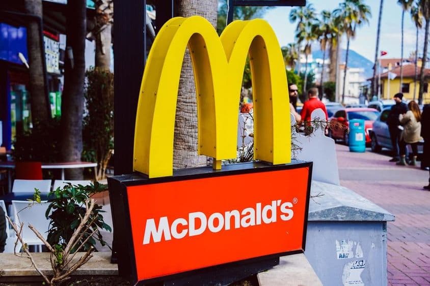 McDonald's-Schild mit Straßenblick im Hintergrund sichtbar.