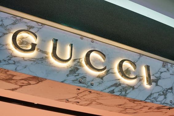 Gucci-Schriftzug in leuchtenden Buchstaben an einer Gebäudefassade.