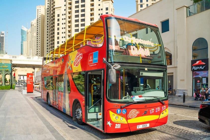 Dubai On & Off-Bus mit Wolkenkratzern im Hintergrund.