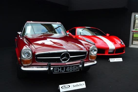 Ein Mercedes und ein Ferrari bei einer Sotheby’s Auktion.