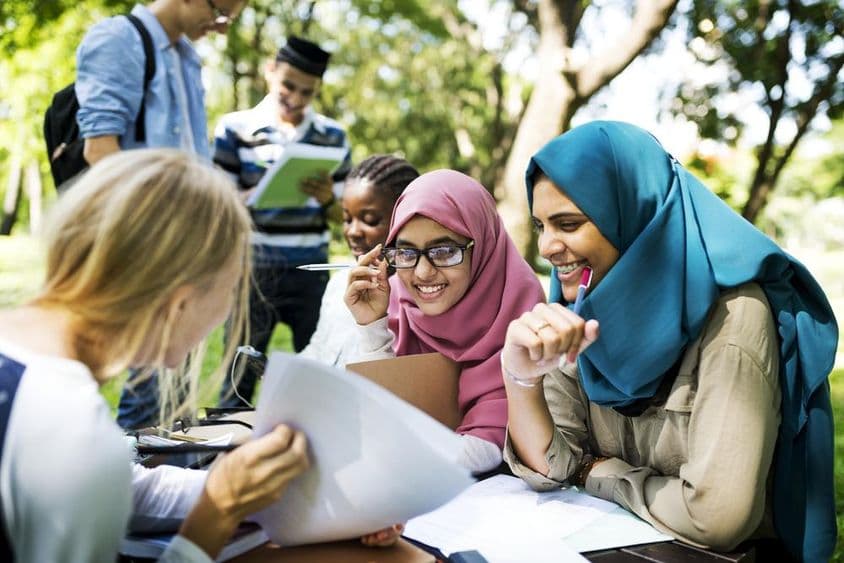 Dubai Schüler schreiben Lektionen und plaudern im Freien.