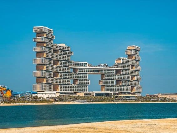 Atlantis The Royal Hotel im Hintergrund mit Wasser und Strand im Vordergrund.