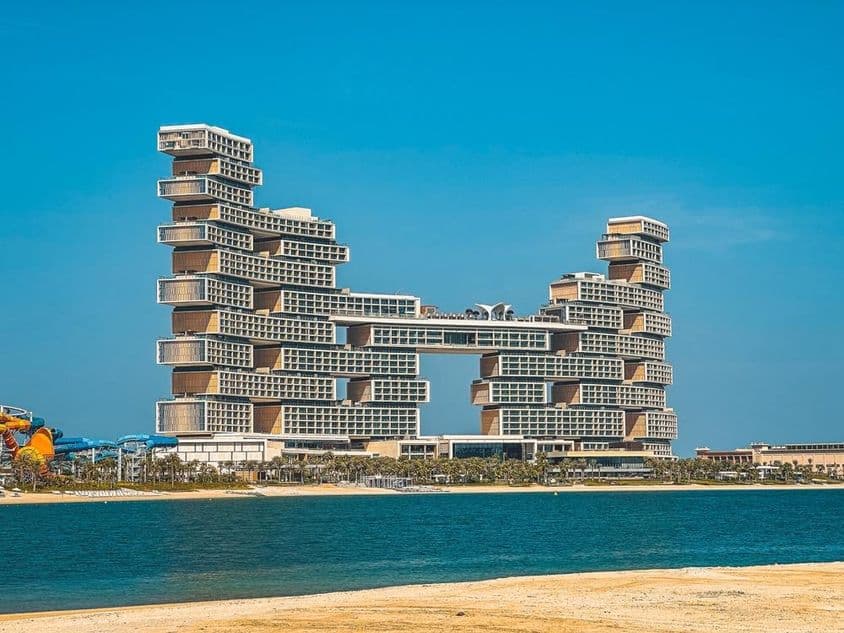 Atlantis The Royal Hotel im Hintergrund mit Wasser und Strand im Vordergrund.