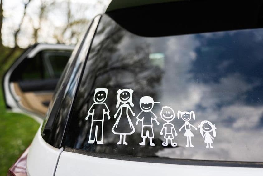 Das Heckfenster eines Autos zeigt einen Aufkleber einer Familie mit 2 Erwachsenen und 4 Kindern.