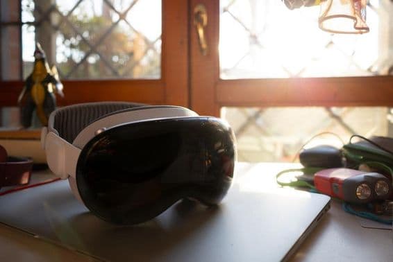 Apple Vision Pro liegt auf einem Notizbuch auf einem Tisch.