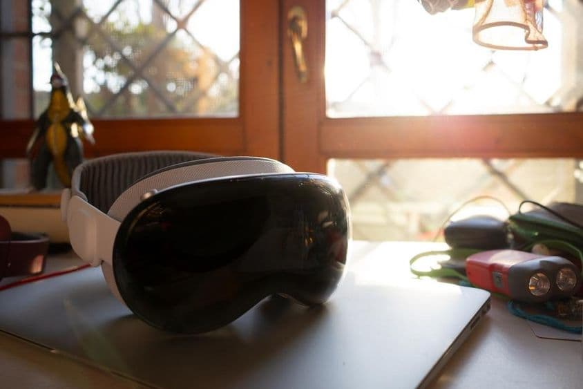 Apple Vision Pro liegt auf einem Notizbuch auf einem Tisch.