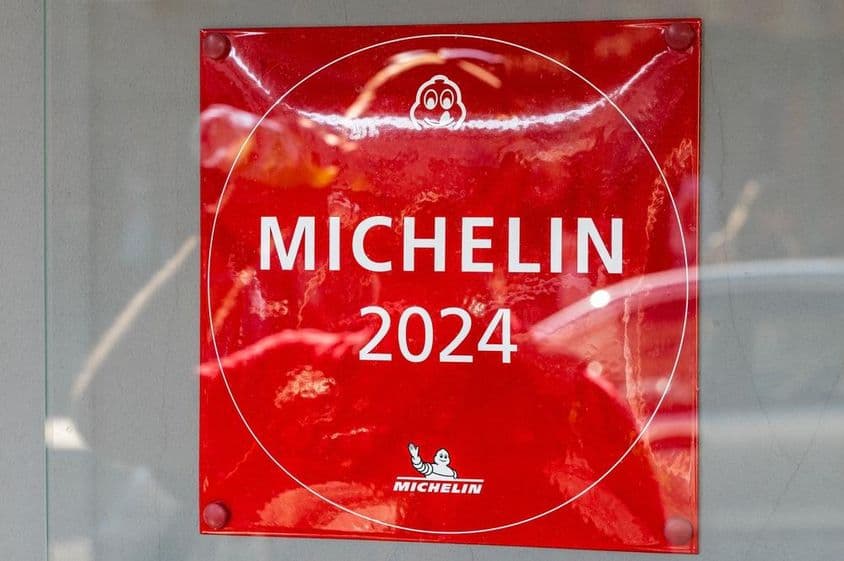 Eine Michelin Guide 2024-Plakette an einer Restaurantwand.