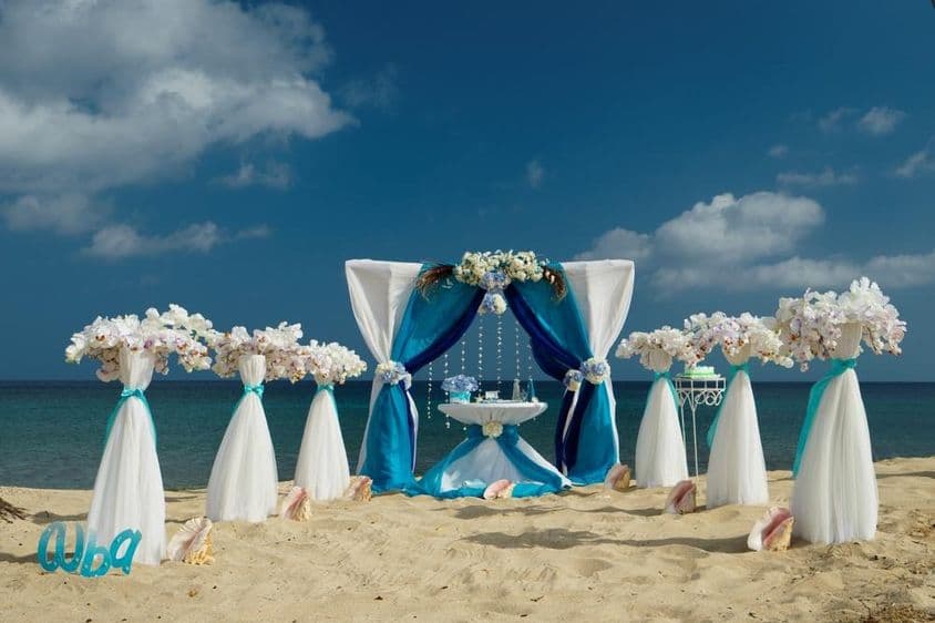 Strandhochzeit auf Sand mit Blumen und kleinem Tisch