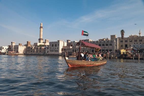 Menschen sitzen auf einem Abra-Boot in Dubai.