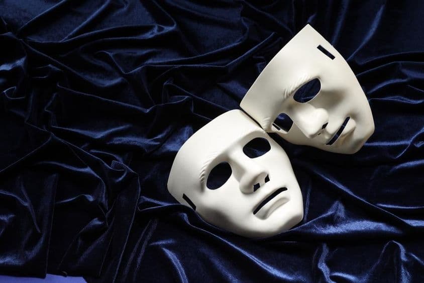 Theater, zwei weiße Masken auf blauem Samt.