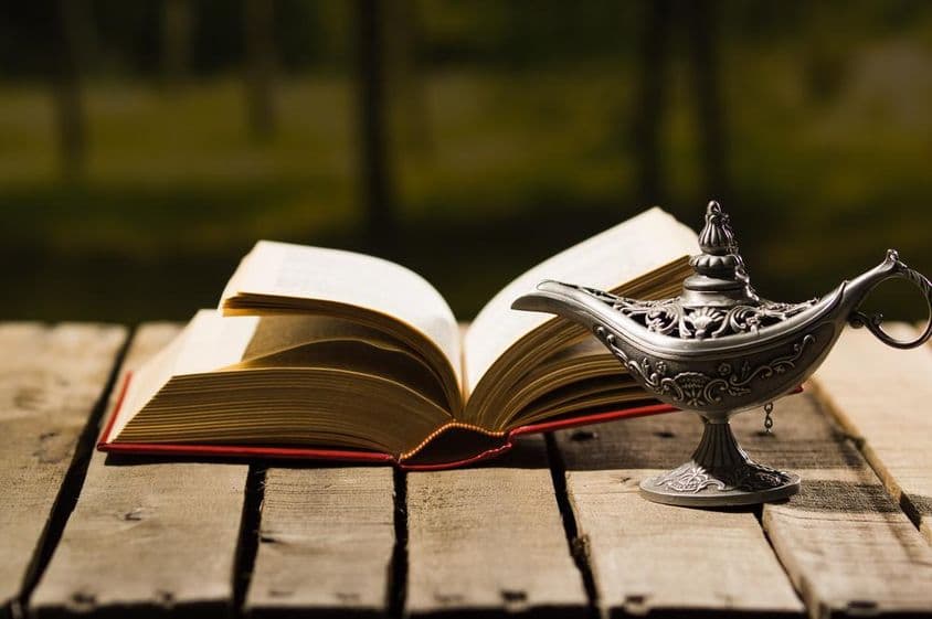 Offenes Buch und alte Lampe.