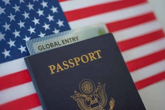 Amerikanischer Reisepass mit einer amerikanischen Flagge im Hintergrund.