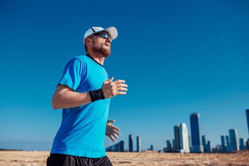 Dubai Triathlon, ein Mann läuft mit Wolkenkratzern im Hintergrund.