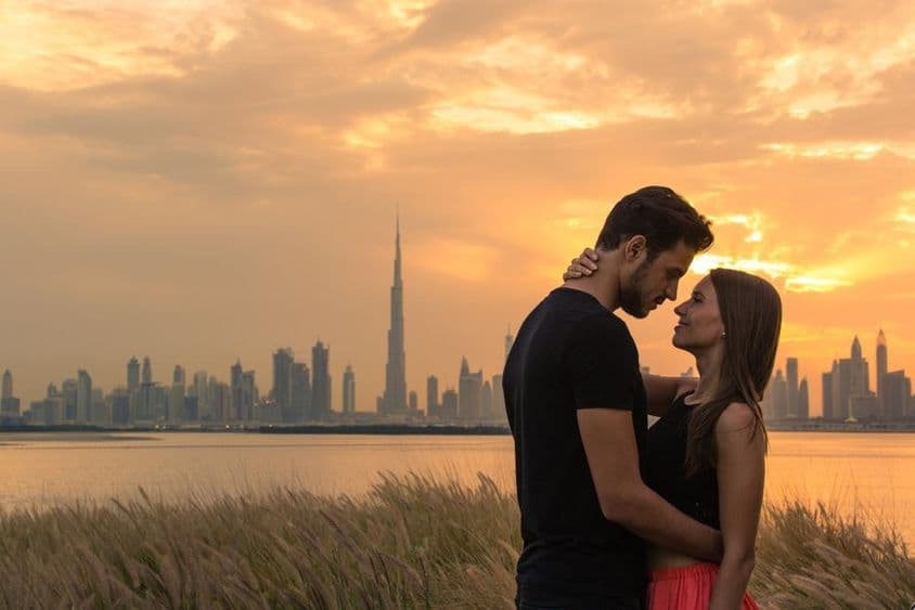 Junges Paar mit Skyline von Dubai im Hintergrund.