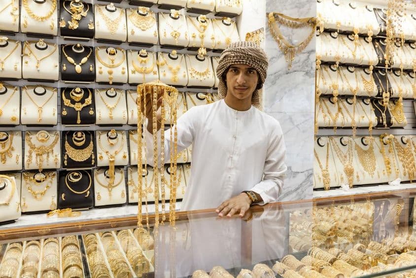 Arabischer Junge zeigt Gold in einem Geschäft.