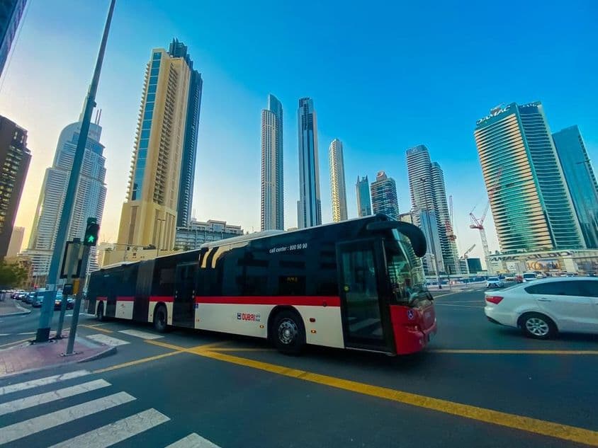 Dubai-Bus mit Wolkenkratzern im Hintergrund.