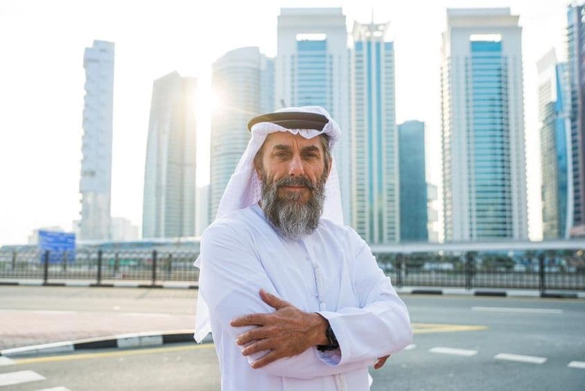 Älterer Mann aus Dubai mit Wolkenkratzern im Hintergrund.