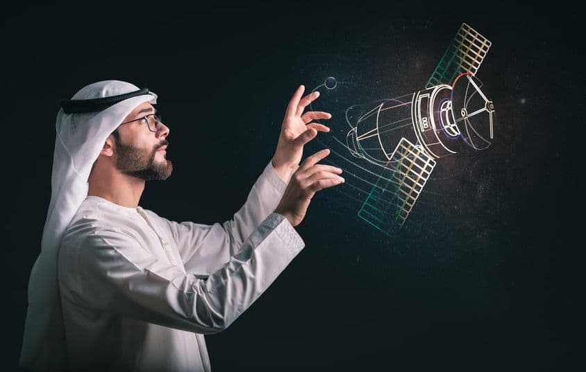 Muslimischer Mann vor projiziertem Satelliten.