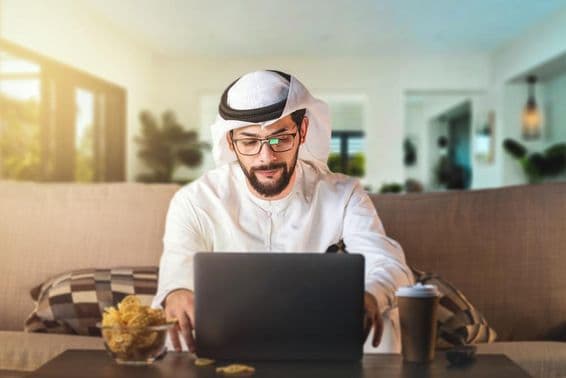 Arabischer Mann studiert mit einem Laptop.