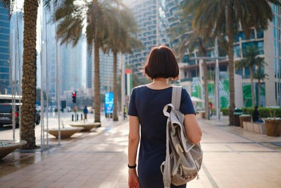 Frau geht in Dubai mit einem Rucksack.