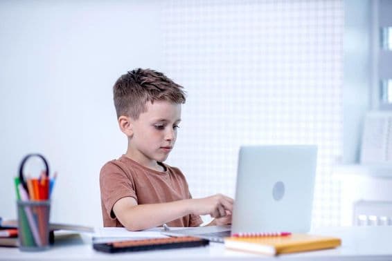 Schuljunge lernt mit einem Computer.