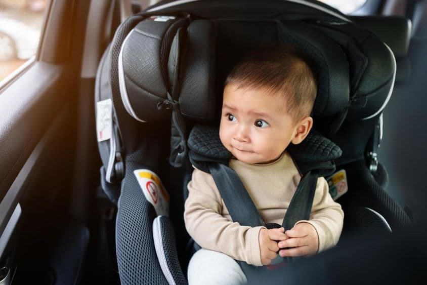 Baby sitzt in einem Autositz.