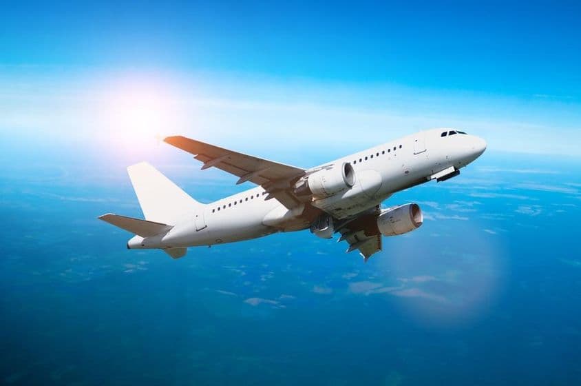 Weißes Flugzeug fliegt am Himmel.