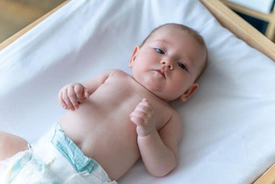 Weißes Baby liegt in einer Windel.