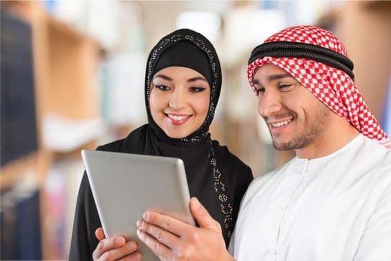 Arabische Studenten schauen sich Studienmaterialien auf einem Tablet an.
