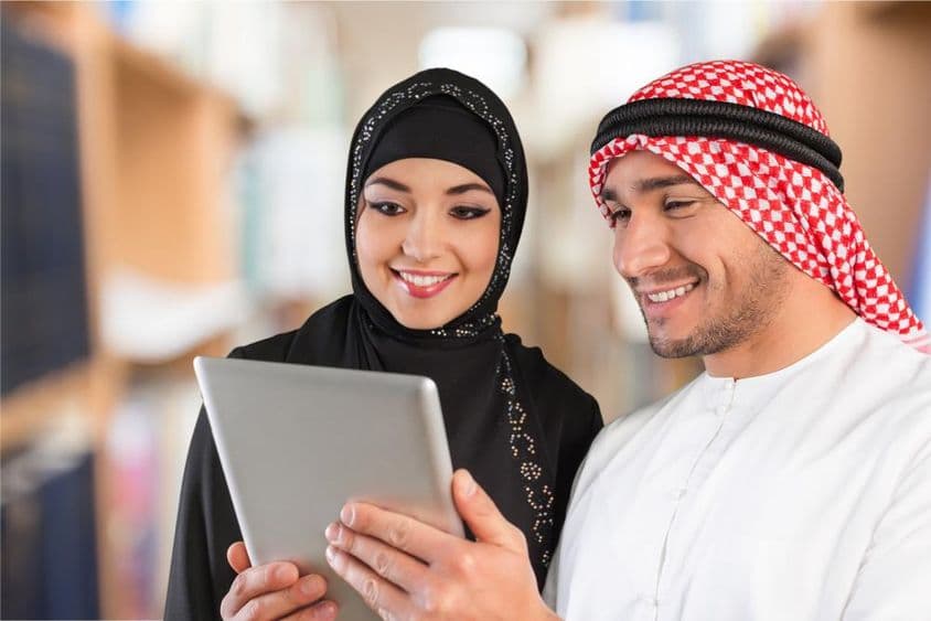 Arabische Studenten schauen sich Studienmaterialien auf einem Tablet an.