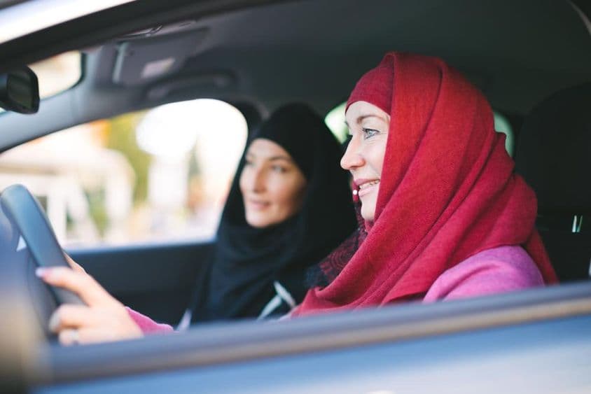 Muslimische Frau am Steuer eines Autos, transportiert eine andere Muslimische Frau.