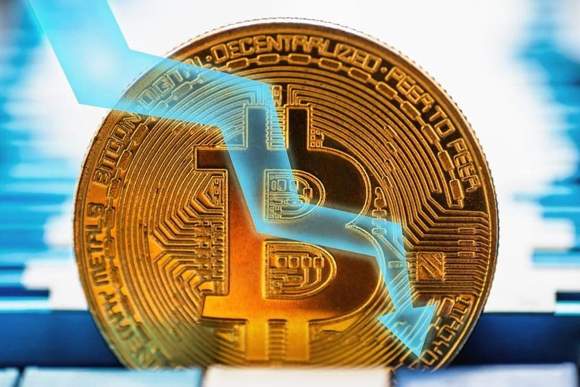 Goldene Bitcoin-Münze - Kryptosymbol und Pfeil, der auf technischem Hintergrund nach unten zeigt.