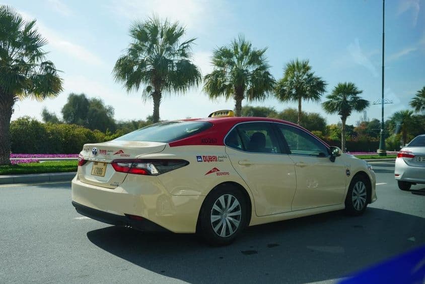 Dubai-Taxi mit rotem Dach fährt auf der Straße.