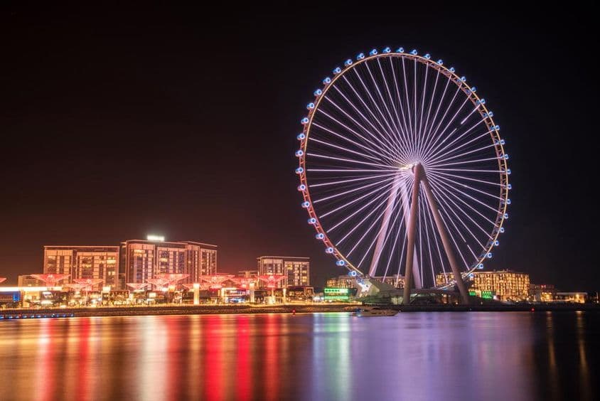 Ain Dubai Riesenrad mit Gebäuden im Hintergrund.