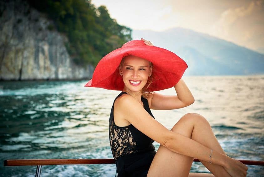 Weibliches Model auf einem hölzernen Motorboot am Comer See in Italien fotografiert.