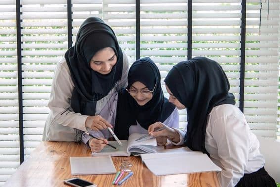 Muslimische Kinder in einem Klassenzimmer, die glücklich lernen.