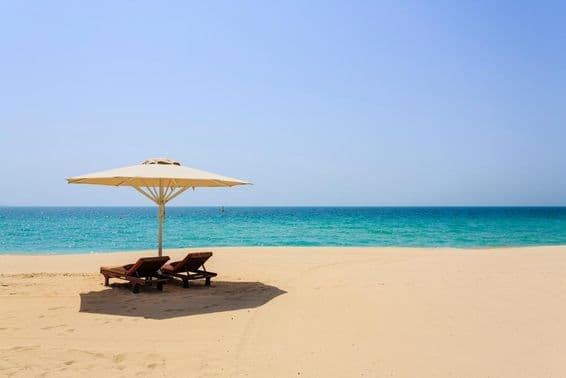 Sonnenliegen am sandigen Jumeirah Beach, Dubai.