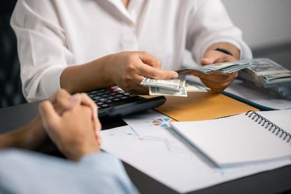 Eine Person verwaltet weise Finanzen, spart Geld aus ihrem Gehalt, sichert stabiles Einkommen für zukünftige Zahlungen und Geschäftsinvestitionen.